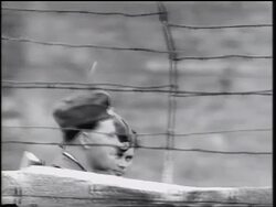 B/W 1961 PAN two East German soldiers walking behind Berlin Wall (only heads visible) / Cold War Stock Footage