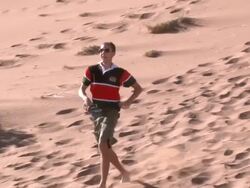 Young man running down sand dune, Dead Vlei, Namib-Naukluft, Namibia Stock Footage