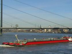 WS View of Dusseldorf city with cargo ship in Rhine river and Oberkassel Bridge / Cologne, North Rhine Westphalia, Germany Stock Footage