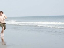  WS SLO MO Woman with squirt gun chasing man at beach / Isle of Palms, South Carolina, USA Stock Footage