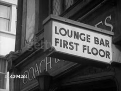 1953: LONDON, ENGLAND: TU 'William Younger & Co' sign & Coach & Horses pub artwork, TD 'Lounge Bar First Floor', WS Westbrook Van Voorhis walking toward Coach & Horses door, locked, walking around to side door & in. Instructional Video