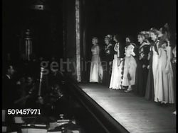 1936: U.S. THEATRE: MUSICOMEDY: NIGHT: Theatre canopy marquee ''Oh Say Can You Sing' WPA Musicomedy.' LA CU Newsboy shouting (SOT). INT VS Orchestra, chorus performers singing 'Oh Say Can You Sing?' (SOT). WS Audience clapping. Instructional Video