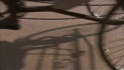 Bicycle wheels roll across pavement. Stock Footage