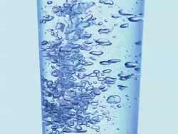 ECU SLO MO Shot of Glass of Sparkling water against Blue background / Calvados, Normandy, France Stock Footage