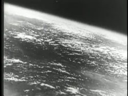 Smoke billows from the launch pad after the Sputnik rocket launches and scientists track its progress in a control room. News Clip