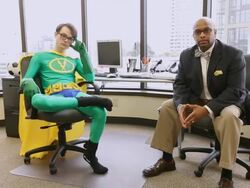 MS PAN One man dressing as superhero in green outfit and yellow cape and business man sitting in office looking towards / Seattle, Washington, United States  Stock Footage