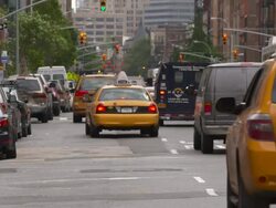cars travel down 7th ave during the daytime.  Taxi cabs line up and turn left. Stock Footage
