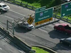 Time lapse traffic racing under a Texarkana and Waco highway sign. Stock Footage