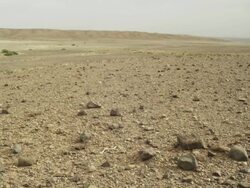 Rocky, stark terrain in the foreground, with the Atlas mountains on the horizon. Stock Footage