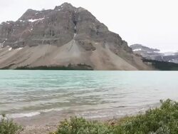 PAN to trail runner looking out across mountain lake Stock Footage