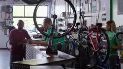 Shop worker hangs price tags on new bikes and manages inventory on tablet computer Stock Footage