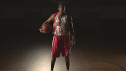 A confident basketball player dribbles a ball at center court. Stock Footage