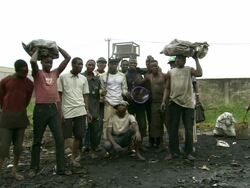 WS View of men like family picture, men sorting scrap metal into bags for weighing with burning copper cable / Lagos, Nigeria Stock Footage