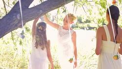 Bride spinning flower girl under tree Stock Footage