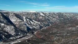 Snow clings to mountainsides beneath a blue sky. Stock Footage
