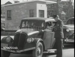 1939: MEXICO-U.S. BORDER: WS Cars approaching border. MS U.S. Customs officer checking motorist's papers. WS Customs inspection station. MS Mexican guard behind counter giving packages to American lady. Instructional Video