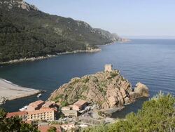 WS HA View of village and genovese tower at rocky coast, UNESCO world heritage / Gulf of Porto, Corsica, France Stock Footage