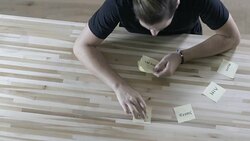 Overhead shot of young entrepreneur arranging sticky notes with strategy words on desk in front of him. Stock Footage