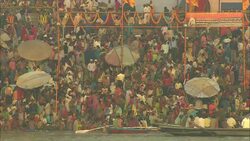 People in India crowd riverbanks, waiting to bathe. Stock Footage