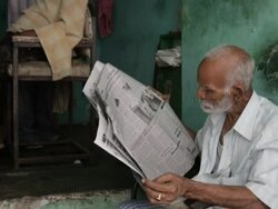 MS TU Man sitting in front of barber shop / Varanasi, India Stock Footage
