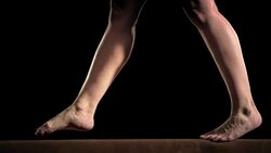 SLO MO Female gymnast doing a balance beam flip Stock Footage