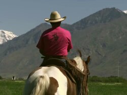 Slow handheld shot of a cowboy riding his horse Stock Footage