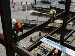 Steelworkers balance on steel support beams Stock Footage