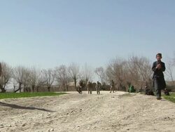 WS Soldiers in landscape, boy shielding eyes / Mausa Qala, Helmand Province, Afghanistan.  Stock Footage