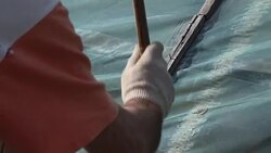 Man hammering the nails to fix greenhouse covering Stock Footage