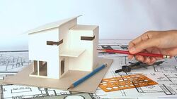Architect working with house model & blueprints Stock Footage
