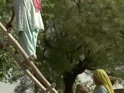 Woman climbing stairs to make pile of manure to be burned into fuel Stock Footage