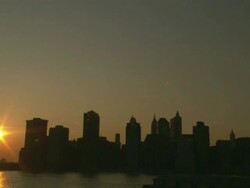 Wide Shot static - A low sun silhouettes the New York City skyline / New York City, New York City, United States Stock Footage