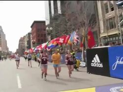 Runners cross finish line just before bomb explosions at Boston Marathon Stock Footage