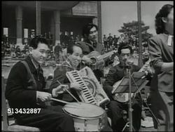 1946: JAPANESE SQUARE DANCING: VS Japanese couples learning to square dance in outdoor arena, band playing music, crowd in stands watching, couples dancing, bowing. Occupied Japan, Democratization Instructional Video
