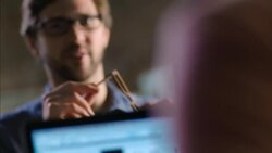 Young woodworker laughs while assembling glasses in shop Stock Footage