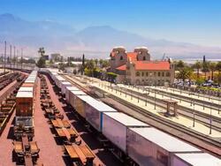 WS T/L freight train carrying shipping containers pulls through rail yard near central train station / San Bernadino, California, USA Stock Footage