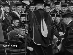 1948: EISENHOWER COLUMBIA UNIVERSITY INAUGURAL: HA WS People sitting in outdoor audience, looking (L), applauding. Dwight D. Eisenhower taking seat on university stage w/ robes people BG, people applauding long, Eisenhower smiling. More applause. Instructional Video