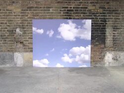 Young man riding bike past sky backdrop Stock Footage