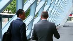 MS TS Two businessmen in discussion while walking outside of office building Stock Footage