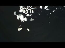 Shards of ice or glass falling against black background Stock Footage