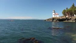 The lighthouse at Lime Kiln State Park on San Juan Island on a sunny day. Stock Footage