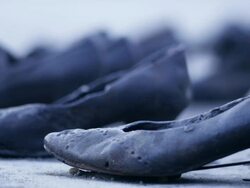 Gloomy exterior day shot. The Shoes on the Danube. Memorial of iron shoes representing Jewish victoms of the Arrow Cross militiamen between 1944 and 1945.  Promenade on the bank of the Danube River in Budapest. Close up on shoes Stock Footage