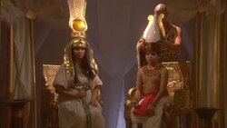 A priest in a leopard skin robe places a crown on a child sitting next to women with a gold crown. Stock Footage