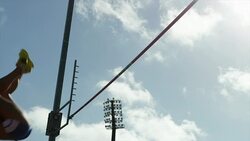 Female pole vaulter jumps and clears bar before pole knocks bar off Stock Footage