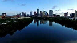 Drifting Away From A Perfect Mirror Image Reflection of the Austin Texas Skyline Cityscape mirrored in Town lake or the Colorado River 4K Stock Footage