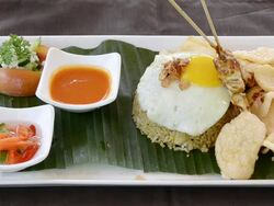 CU Dish of Nasi Goreng with fried rice, chicken, egg, kerupuk crackers, pineapple juice and balinese food at Asia / Ubud, Bali, Indonesia Stock Footage