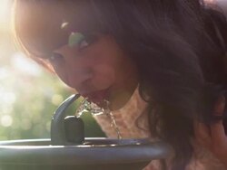 MS TU SLO MO Shot of beautiful brunette drinking water from fountain in rose garden / Portland, Oregon, United States  Stock Footage