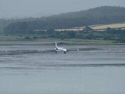 Aerial wide shot pan plane landing at City of Derry Airport / Derry, Ireland Stock Footage