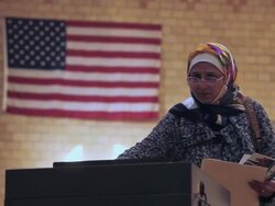 November 2, 2010 MS A voter from the Arab community files her completed ballot with an American flag on the wall behind her / Dearborn, Michigan, United States Stock Footage