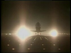 Silhouette of Space Shuttle Discovery landing toward camera at night Stock Footage